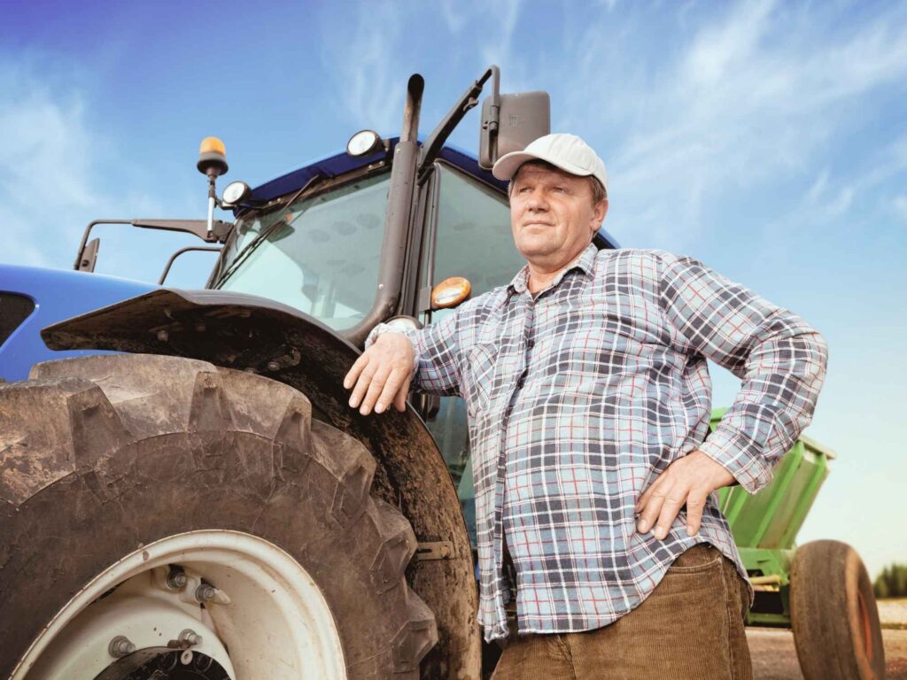 Farmers worried about his property rights standing next to a tractor